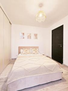 een slaapkamer met een groot bed en een kroonluchter bij Bed & Breakfast - Entre Paris & Disneyland in Roissy-en-Brie