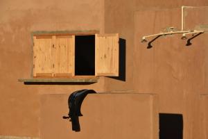 ダフラにあるSecret Spot Dakhlaの壁面に木製の窓とパイプが付いている