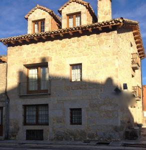 a large stone building with windows and a chimney at Auténtica casa rural con encanto by beBalmy in Sorihuela