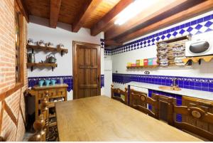 a kitchen with blue tiled walls and a wooden table at Auténtica casa rural con encanto by beBalmy in Sorihuela