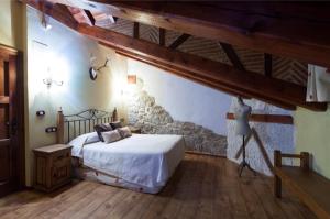 a bedroom with a bed and a wooden floor at Auténtica casa rural con encanto by beBalmy in Sorihuela