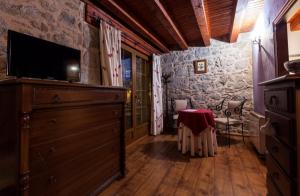 a room with a dresser with a television and a table at Auténtica casa rural con encanto by beBalmy in Sorihuela