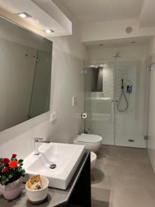 bagno con lavandino, servizi igienici e specchio di Domu Qirat - Authentic Rooms & Terraces a Tortolì