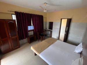 HOTEL ROYAL PARK في منغالور: غرفة نوم بسرير ومكتب ونافذة