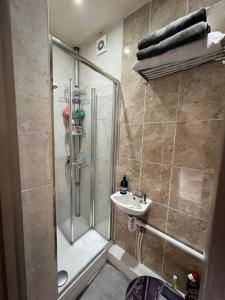ein Bad mit einer Dusche und einem Waschbecken in der Unterkunft 1 Bedroom home with hot tub & private garden in Orpington