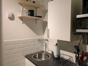 una cucina con lavandino e piano di lavoro di 1 Bedroom home with hot tub & private garden a Orpington