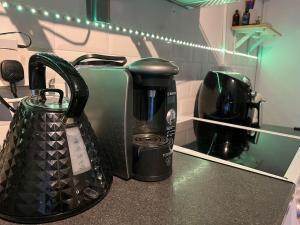 eine Küchentheke mit Kaffeemaschine und Wasserkocher in der Unterkunft 1 Bedroom home with hot tub & private garden in Orpington