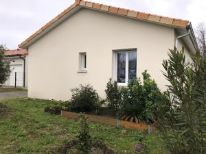 une maison blanche avec une fenêtre dans une cour dans l'établissement L’aureilhannaise, à Aureilhan