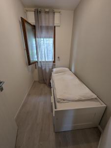 a small bedroom with a bed and a window at Casa Marica - Appartamento nel Borgo di Pieve in Tremosine Sul Garda