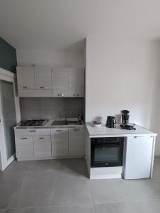 a kitchen with white cabinets and a stove top oven at Casa Marica - Appartamento nel Borgo di Pieve in Tremosine Sul Garda