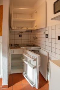 an empty kitchen with an open refrigerator in it at Airport Studio Innsbruck I Free Parking in Innsbruck