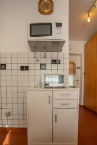 a kitchen with a microwave on top of a counter at Airport Studio Innsbruck I Free Parking in Innsbruck