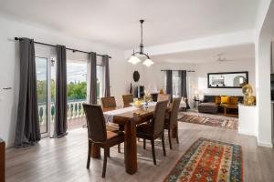 a dining room and living room with a table and chairs at Casa Alegria Carvoeiro in Carvoeiro