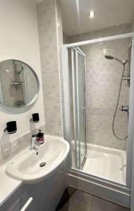 a bathroom with a shower and a sink and a mirror at Spacious 2 Bedroom Apartment With Balcony In Jewellery Quarter, Birmingham City Centre in Birmingham