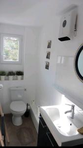 La salle de bains blanche est pourvue de toilettes et d'un lavabo. dans l'établissement Studio indépendant terrasse entre mer et collines, à Marseille