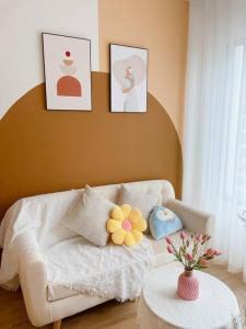 sala de estar con sofá blanco y cuadros en la pared en AmHome Premium Vinhome OceanPark en Hanoi