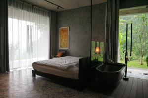 sypialnia z łóżkiem, wanną i oknem w obiekcie Ann's Villa Hill Hoa Binh City w mieście Hòa Bình