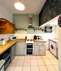 a kitchen with white appliances and a chalkboard on the wall at Charming cottage retreat with garden - sleeps 12 in Bristol