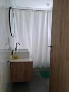 a bathroom with a sink and a white shower curtain at Sweet Home in Junín
