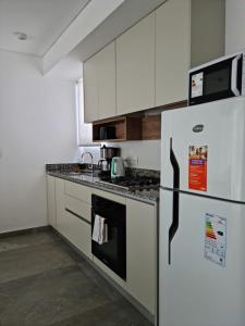 a kitchen with white cabinets and a refrigerator at Sweet Home in Junín