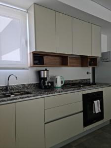 a kitchen with white cabinets and a counter top at Sweet Home in Junín