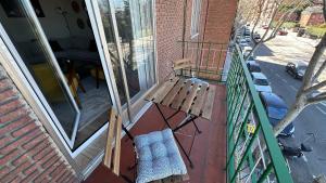 un banco de madera sentado en un balcón junto a una ventana en Apartamento Metropolitano IV en Madrid en Madrid