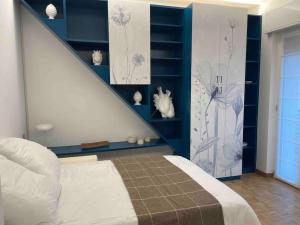 1 dormitorio con 1 cama blanca y paredes azules en Grazioso appartamento vicino al Lago di Como, en Erba