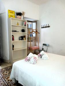 Una habitación con una cama con toallas. en Alojamientos con encanto en casa de patio, en Córdoba