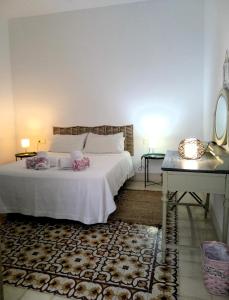 a bedroom with a white bed with a table and a desk at Alojamientos con encanto en casa de patio in Córdoba