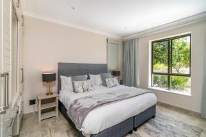a bedroom with a large bed and a window at Super Beachfront views- Executive Villa - 6 bedrooms in Knysna