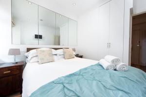 倫敦的住宿－Chic Apartment - Fabulous central location in Zone 1，卧室配有带毛巾的大型白色床