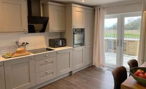 a kitchen with white cabinets and a large window at Linwood in Lincoln