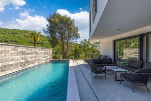 a house with a swimming pool and a patio at Villa Visum Mare Unus in Mošćenička Draga