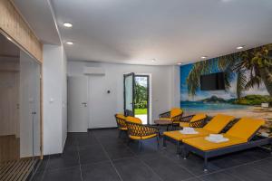 a waiting room with a yellow table and chairs at Villa Visum Mare Unus in Mošćenička Draga +3 photos