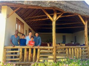 una famiglia che si trova di fronte a una casa di Euphorbia Safari Lodge a Kasenyi