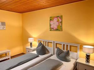 two beds in a room with yellow walls at Zum Zacherwirt in Hengersberg