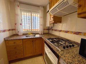 a kitchen with a sink and a stove top oven at Apartamentos Vistamar Marina D'Or 1º línea 3000 in El Borseral