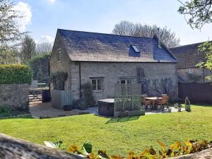 an old stone house with a garden and a table at Braeburn - Uk38098 in Pilton