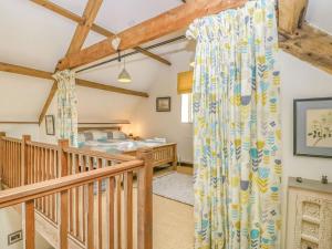 a cottage bedroom with a bed and a wooden staircase at Braeburn - Uk38098 in Pilton