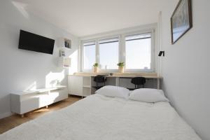 華沙的住宿－Pretty Studio Apartment in Warsaw City Centre by Renters，白色卧室配有床和书桌