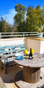 Salento Houses & Idro Suites في ناردو: طاولة خشبية مع كأسين صفراء على سطح السفينة