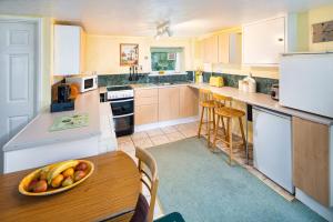a kitchen with a table with a bowl of fruit on it at Lower Cottage Newcastle Emlyn in Cwm-pengraig