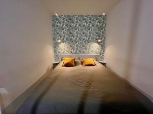 Bett in einem Zimmer mit zwei gelben Kissen in der Unterkunft AA P Terrasse de Stella in Nizza