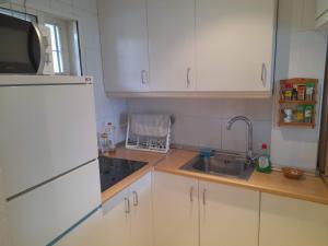 a kitchen with white cabinets and a sink and a microwave at Apartment with pool near the beach in Marbella