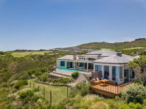 een luchtzicht op een huis met een zwembad bij Pezula Beachfront Splendour - 5 bedroom in Knysna