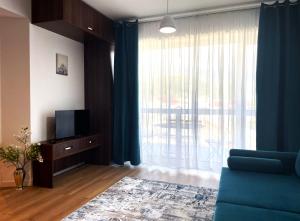 uma sala de estar com um sofá azul e uma grande janela em Sinaia Walter Apartment em Sinaia