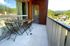 a balcony with a table and chairs on a balcony at Sinaia Walter 20 Apartment w Paid Pool and Free Parking in Sinaia