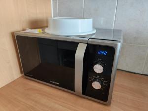 a microwave with a cake on top of it at Room in Shared Apartment Geneva in Geneva