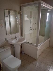 uma casa de banho com um lavatório, um chuveiro e um WC. em Costal Road hideout em Brufut