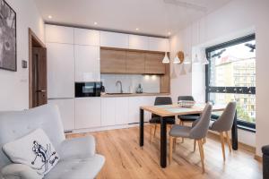 a kitchen and dining room with a table and chairs at TATRYSTAY Armeria Apartments in Vysoke Tatry - Strbske Pleso